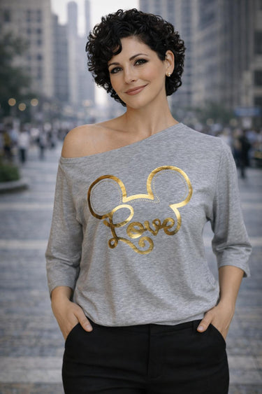 Серая футболка с одним открытым плечом и золотым принтом.